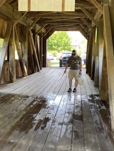 Volunteer applying NoChar fire retardant to the floor of Fort Hunter Covered Bridge, Dauphin County